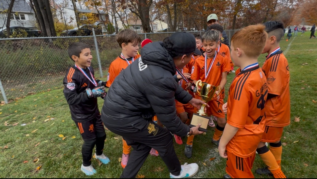 Inter NJ Garfield players celebrating with a trophy
